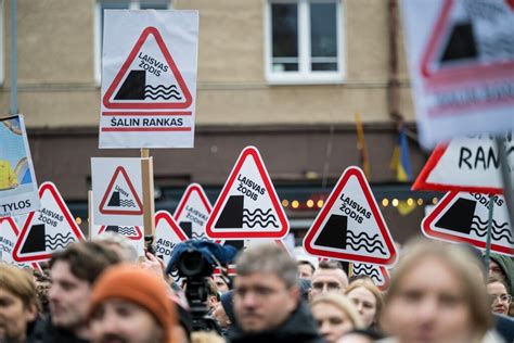 Dvi rankos, spaudžiančios rankas prie popierinių dokumentų, simbolizuojančių sandorio patvirtinimą
