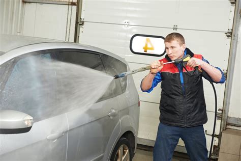 automobilio plovimas savitarnos plovykloje, asmuo su plovimo pistoletu