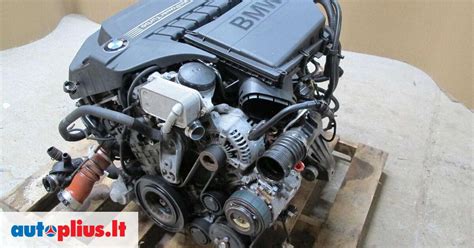 Nuotrauka, vaizduojanti BMW E60 variklio skyrių su pažymėtu generatoriumi
