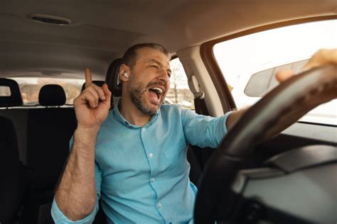 Teminė nuotrauka: du žmonės automobilyje, vienas vairuoja, kitas šalia