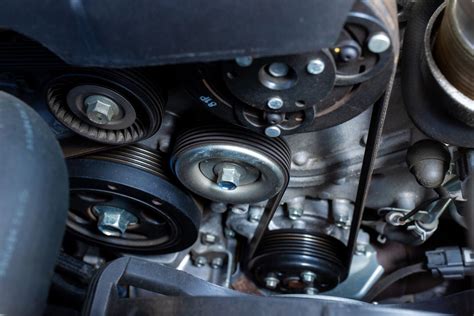 Thematic photo of a car engine bay with emphasis on the serpentine belt routing