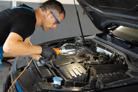 Safety image: a mechanic wearing gloves and safety glasses working on a car engine