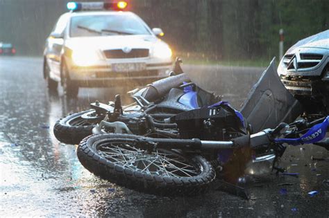 Motociklas po avarijos prie kelio apsauginių atitvarų
