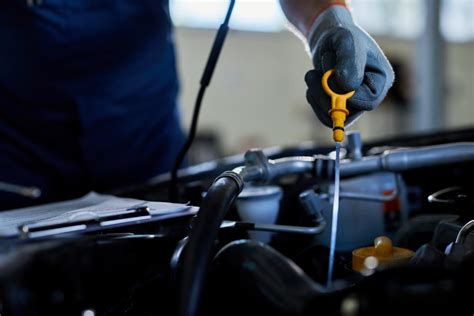Nuotrauka su meistru, tikrinančiu automobilio variklį