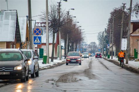 Slidžių kelių atkarpa žiemą su šlapdriba ir įspėjamaisiais ženklais
