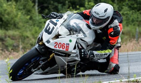 Motociklininkas atlieka sudėtingą triuką lenktynių metu.