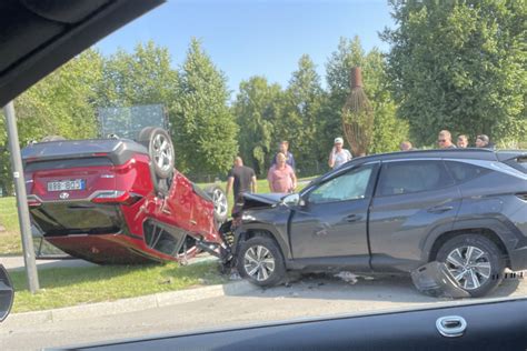 tamsios spalvos Mercedes-Benz automobilis po smūgio įvažiavęs į daugiabučio kiemą ant žalios vejos