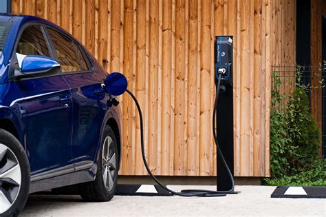 nuotrauka, iliustruojanti elektromobilį su įkrovimo stotele