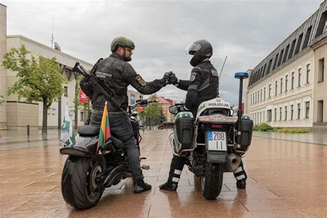 Motociklininkas su vaiku ant motociklo, dėvintys apsaugines priemones