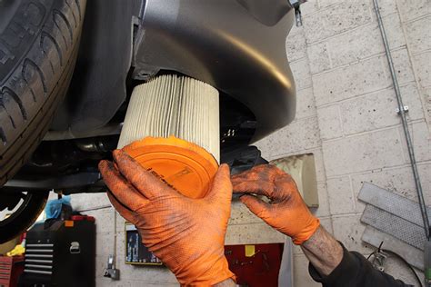 The process of removing a car battery and air filter box from an engine bay