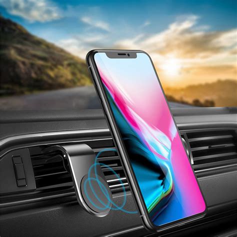 automobilio salono nuotrauka su telefonu, pritvirtintu prie priekinio stiklo, rodančiu navigacijos žemėlapį