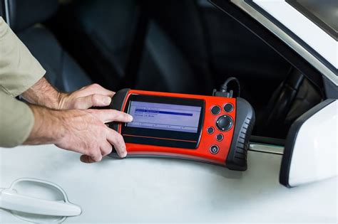 Mechanikas jungia diagnostikos įrangą prie automobilio OBD prievado