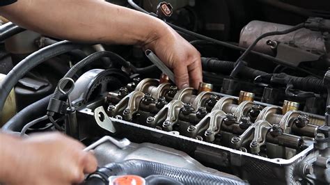 Renault Scenic su atidarytu variklio dangčiu ir meistru prie valdymo bloko