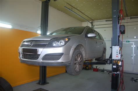 Automobilis pakeltas ant stovų, paruoštas pusašio keitimui