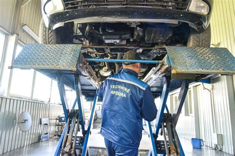 Tematinė nuotrauka: Mechanikas, tikrinantis automobilio važiuoklę techninės apžiūros metu