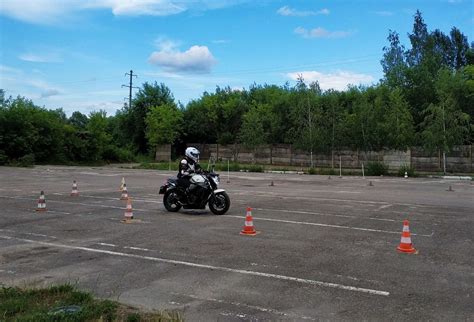 Motociklo vairavimo mokyklos aikštelė su mokiniais ir instruktoriumi