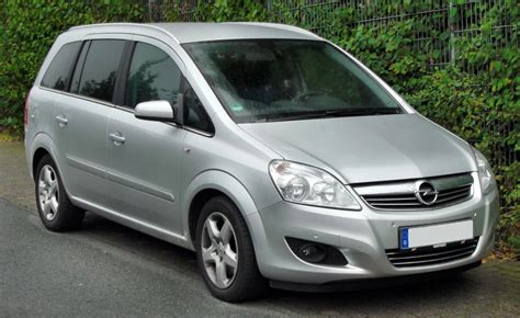 The Opel Zafira car and various spare parts around it, a mix of new and used parts