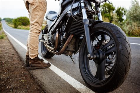 Motociklininkas, demonstruojantis pusiausvyrą stovint ant motociklo