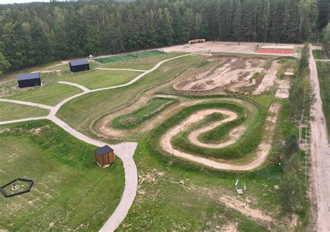 Vairavimo mokyklos aikštelė su motociklais ir instruktoriumi