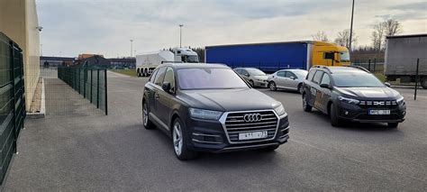 Teminė nuotrauka: besimokantysis vairuoja automobilį su instruktoriumi, aiškiai matoma mokomoji aikštelė