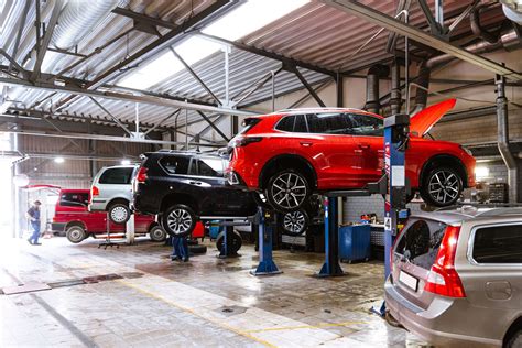 Nuotrauka, vaizduojanti „Opel“ automobilį servise su meistru, atliekančiu diagnostiką