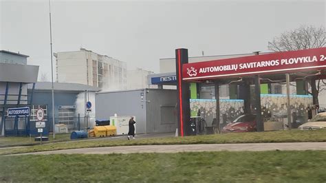 Teminė nuotrauka: besišypsanti klientė prie savitarnos plovyklos mokėjimo terminalo