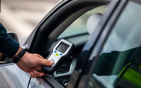 Tematinė nuotrauka, vaizduojanti alkotesterį ir automobilio raktelius