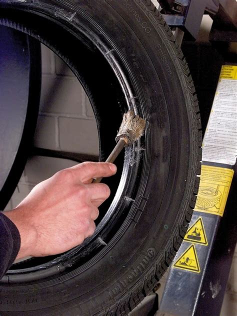 meistras montuojantis naują padangą ant ratlankio servise