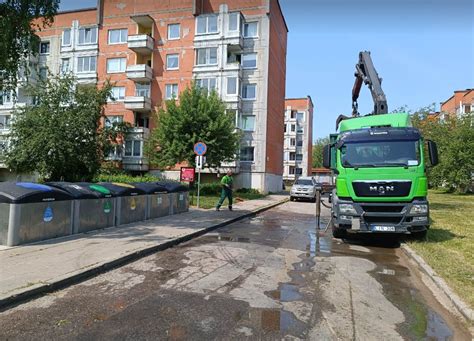 Ecoservice sunkvežimis su atliekomis kraunančiu konteinerį