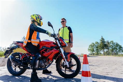 Motociklas, slystantis ant slidžios trasos, su instruktoriumi