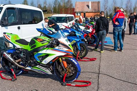 Grupė motociklininkų treniruojasi trasoje su instruktoriumi
