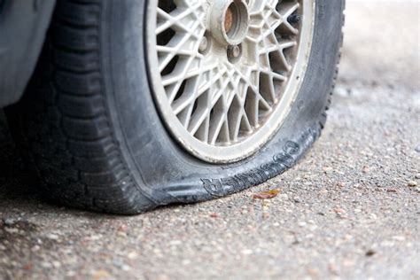 Tematinė nuotrauka: sugadinta padanga kelyje ir automobilis važiuojantis su run-flat padanga
