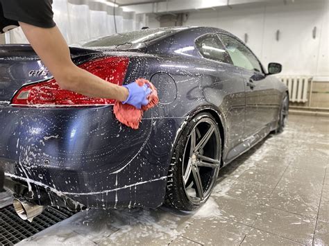 Profesionalus rankinis automobilio plovimas, pabrėžiant kruopštumą ir detales