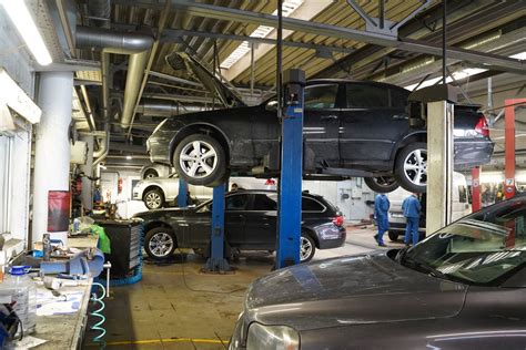 Tematinė nuotrauka: modernus autoservisas su dirbančiais mechanikais