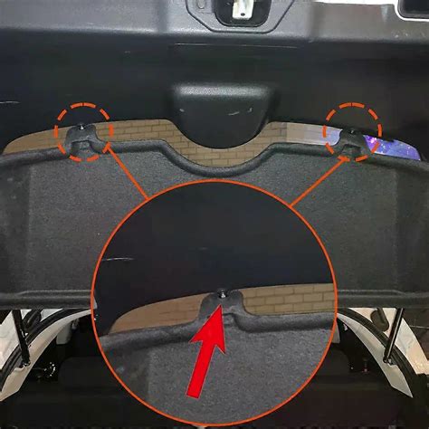 A close-up of a broken plastic clip on a car parcel shelf/trunk curtain mechanism