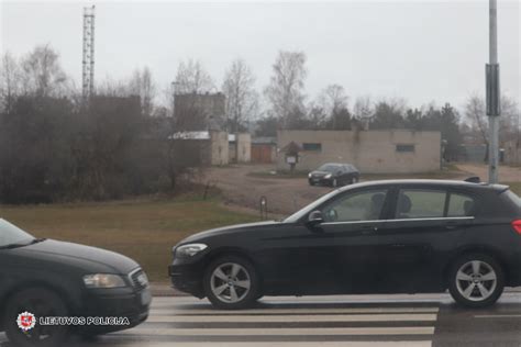 Jaunas žmogus, sėdintis prie vairo su instruktoriumi, mokantis vairuoti