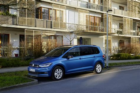 Thematic photo of a Volkswagen Touran with a family, maybe on a trip or loading luggage.
