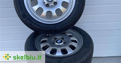 BMW X5 su originaliais ratlankiais, važiuojantis keliu, iliustruojantis automobilio stabilumą