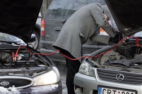 Teminė nuotrauka: vyras keičia automobilio akumuliatorių