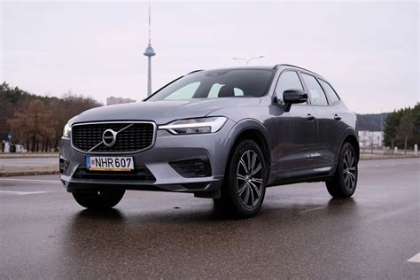 iliustracija, kurioje pavaizduotas Volvo XC60 automobilis su šalia esančiu planšetiniu kompiuteriu, rodančiu elektroninę vartotojo vadovo versiją