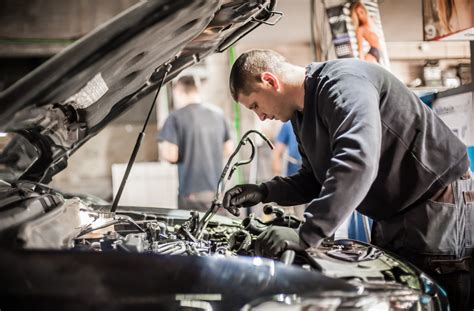 Teminė nuotrauka: Automobilių meistrai dirba su automobilio varikliu autoservise