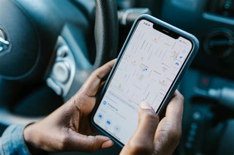 Teminė nuotrauka: žmogus, naudojantis navigacijos programėlę automobilyje