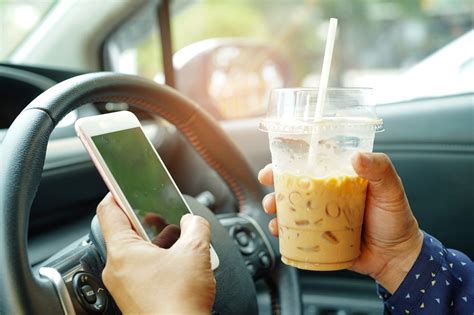 Teminė nuotrauka: Vairuotojas, žiūrintis į mobilųjį telefoną vairuodamas, iškraipytas vaizdas