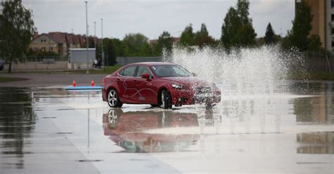 Nuotrauka iš ekstremalaus vairavimo mokymų: automobilis slysta kontroliuojamai trasoje.