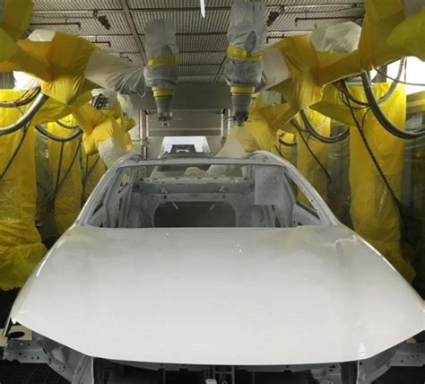 Procesas, kaip pulverizatoriumi dengiami dažų sluoksniai ant automobilio.