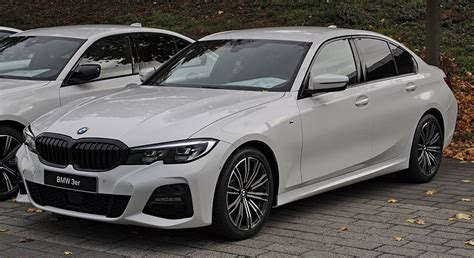 Nuotrauka, vaizduojanti skirtingų kartų BMW automobilių (pvz., E36, F30, G20) priekines duris su matomomis garsiakalbių vietomis.