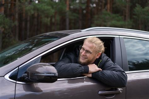 Ransomas Eli Oldsas prie savo pirmojo automobilio su Franku G. Clarku ir žmonomis