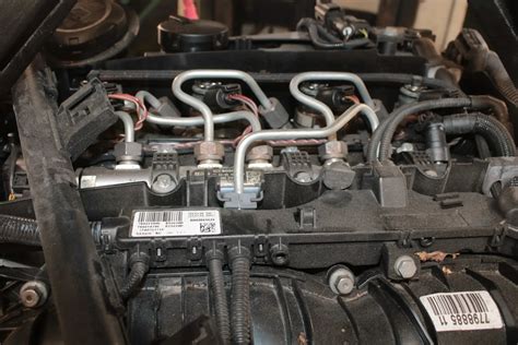 BMW E90 variklio skyriaus išdėstymo schema su pažymėtais žibintų blokais