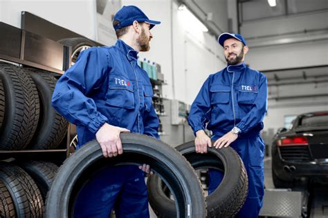 Tematinė nuotrauka: modernus padangų servisas su specialistu prie automobilio