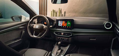 The modern interior of the Seat Arona, highlighting the dashboard, central console, infotainment system, and wireless charging pad.